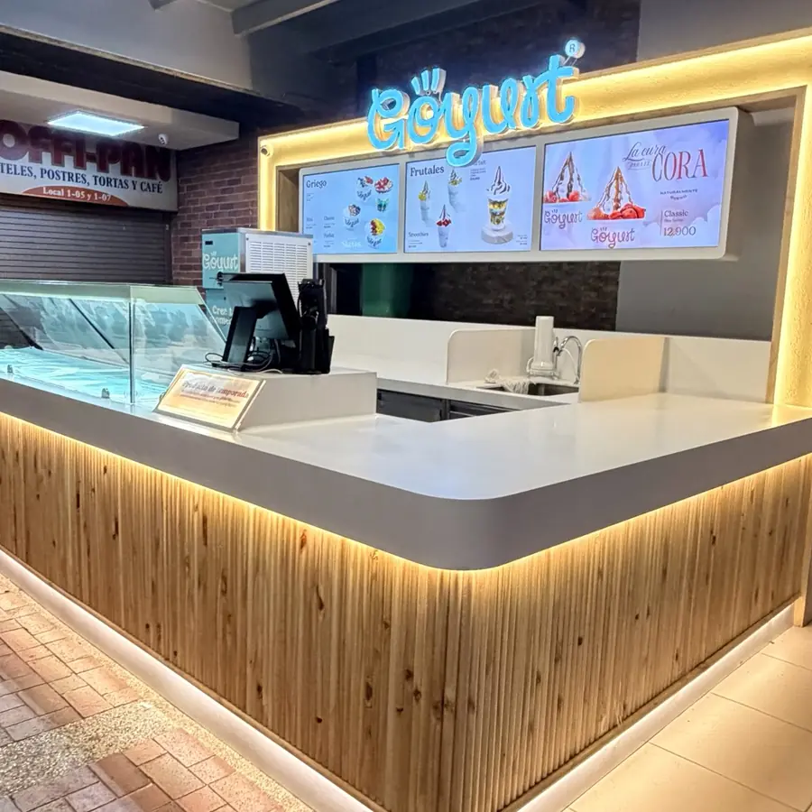 Isla comercial de Göyurt con mostrador iluminado en madera, diseñada por Lado Beta