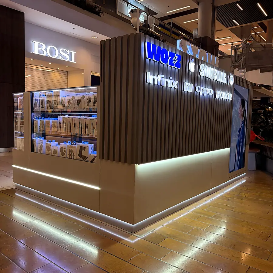 Isla comercial de Wozz con listones y letras iluminadas de marcas de celulares